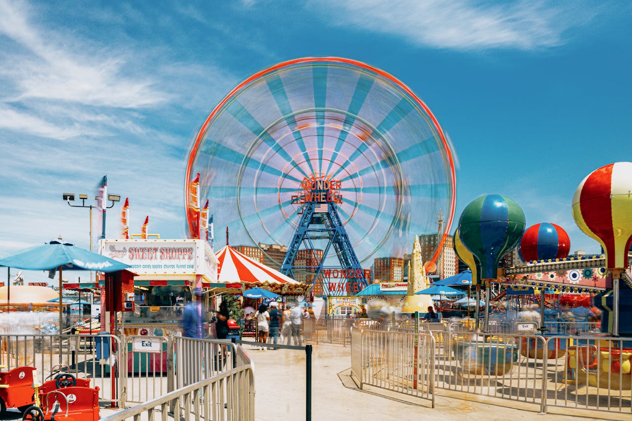 Vibrant scene of Ferris wheel and attractions at Coney Island, New York.